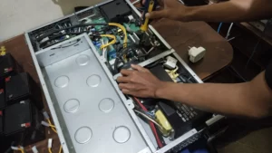 seorang teknisi sedang memperbaiki UPS server